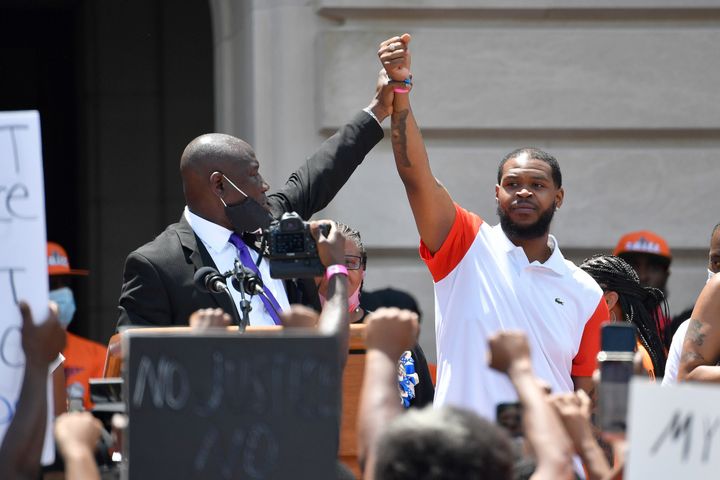 Attorney Benjamin Crump, left, holds up the hand of Kenneth Walker during a rally on the steps of the Kentucky State Capitol in Frankfort, Ky., on June 25, 2020. Walker, the boyfriend of Breonna Taylor who fired a shot at police as they burst through Taylor's door the night she was killed, has settled two lawsuits against the city of Louisville, his attorneys said Dec. 12, 2022. 
