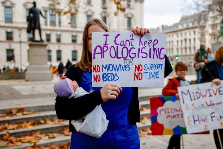 A midwife holds a placard during March With Midwives.