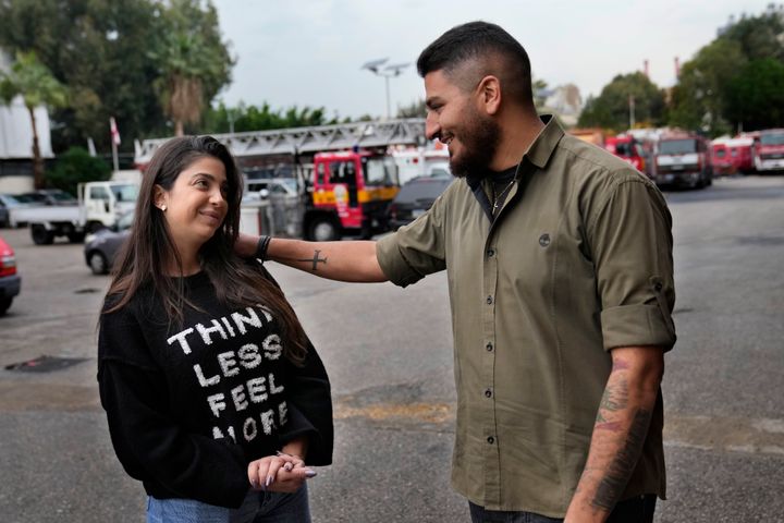 William Noun, right, whose brother Joe was a firefighter and killed during Beirut blast on Aug. 4, 2020, talks to his fiancee Maria Fares, left, whose sister Sahar was also a firefighter and killed in the same blast, at the firefighter headquarters, in Beirut, Lebanon, Wednesday, Dec. 14, 2022. It was a sad moment during which William Noun and Maria Fares met two years ago after their siblings were killed in Beirut's massive port blast. The couple got engaged this month and plan to get married next summer. (AP Photo/Hussein Malla)