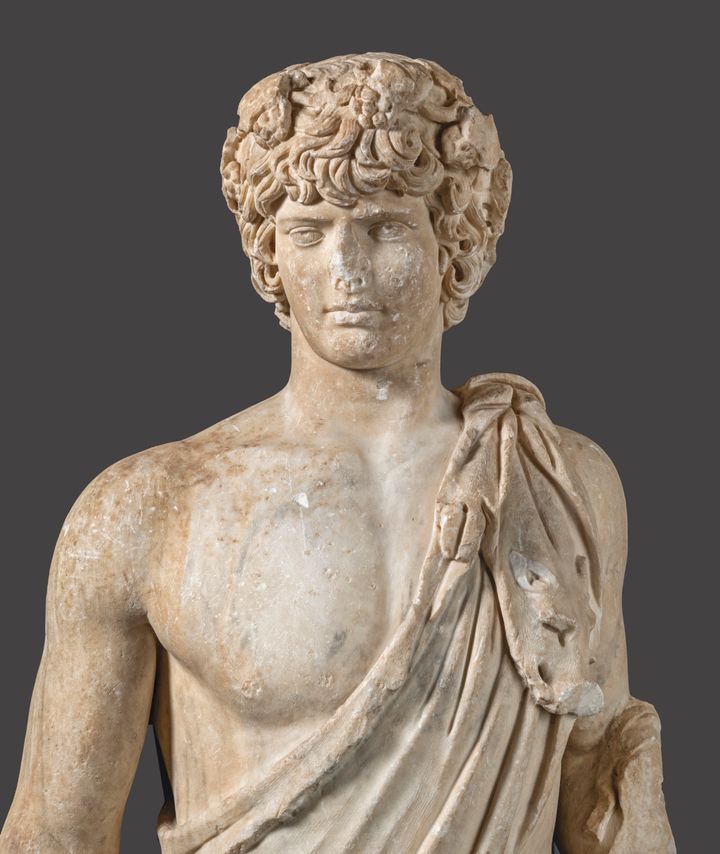 Άγαλμα νεαρού άνδρα (Αντίνοου) από πεντελικό μάρμαρο. Βρέθηκε σε κυκλικού σχήματος θολωτό βαλανείο στα Λουτρά Αιδηψού. Μέσα του 2ου αι. μ.Χ.