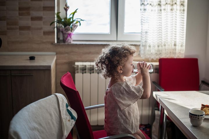 Vira*, two, sits in her kitchen for a portrait in Suceava county, northern Romania
