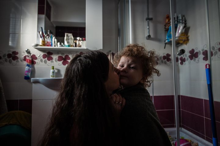 Elena*, 36, hugs her daughter Vira*, two, in the bathroom at their home Suceava county, northern Romania