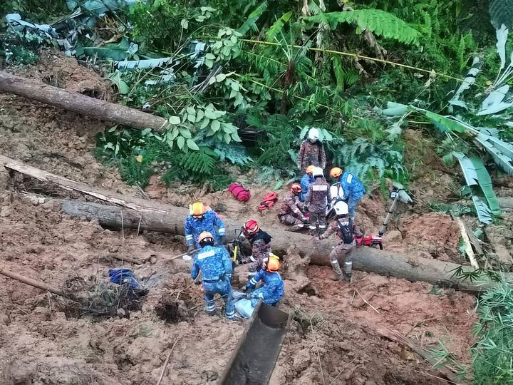 In this photo provided by Civil Defense Department, Civil Defense personnel search for missing persons after a landslide hit a campsite in Batang Kali, Malaysia on Friday. A landslide hit the campsite outside Kuala Lumpur early Friday, Malaysia's fire department said.