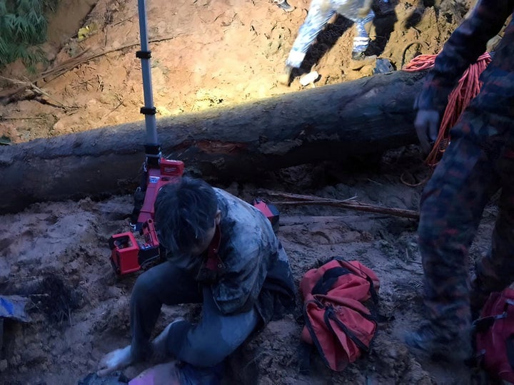 In this photo released by Korporat JBPM, a survivor sits at a campsite, following a landslide in Batang Kali, Selangor state, on the outskirts of Kuala Lumpur, Malaysia on Friday.