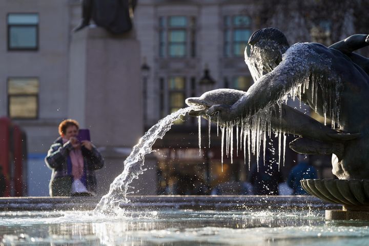Taking pictures of a frozen fountain in Trafalgar Square, central London. Snow and ice have swept across parts of the UK, with cold wintry conditions set to continue.