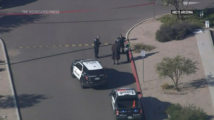 This image made from video provided by KNXV shows law enforcement outside an Amazon delivery hub in the Phoenix suburb of Chandler, Ariz., Wednesday, Dec. 14, 2022. Police say that a person with a gun shot and wounded a contract worker outside the Amazon delivery station in Arizona before another contract worker who was armed fatally shot the suspect in the parking lot Wednesday, possibly stopping an active shooter situation. (KNXV via AP)