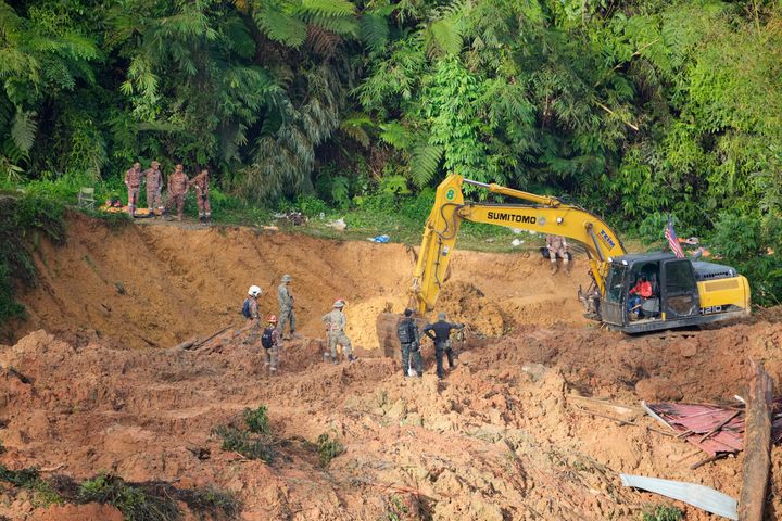 Les équipes de secours utilisent une pelleteuse pour poursuivre la recherche des victimes prises dans un glissement de terrain à Batang Kali, en Malaisie, samedi.  Les autorités ont déclaré qu'une douzaine de personnes craignaient d'être enterrées sur le site d'une ferme biologique à l'extérieur de la capitale de Kuala Lumpur.
