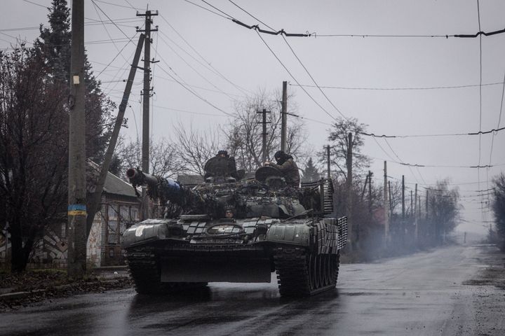 Members of the Ukrainian military drive a tank down a residential street in Bakhmut as Russia continues its military campaign.