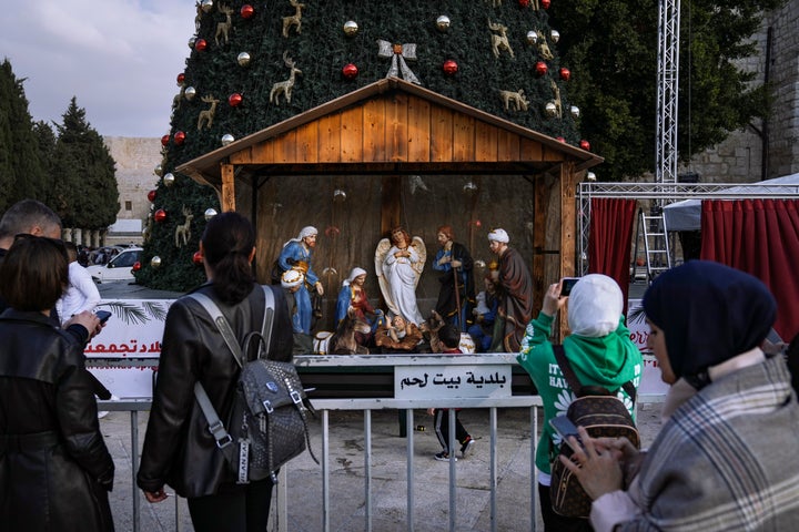 Turistas y locales fotografían el portal de belén instalado en la Plaza del Pesebre de Belén, con la Natividad al fondo, el pasado 5 de diciembre.