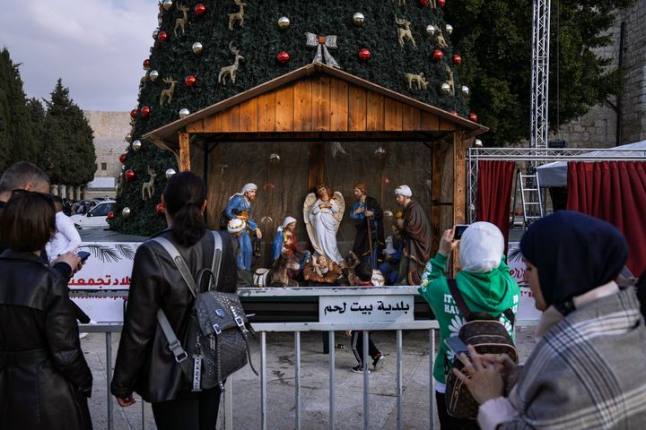 Turistas y locales fotografían el portal de belén instalado en la Plaza del Pesebre de Belén, con la Natividad al fondo, el pasado 5 de diciembre. 