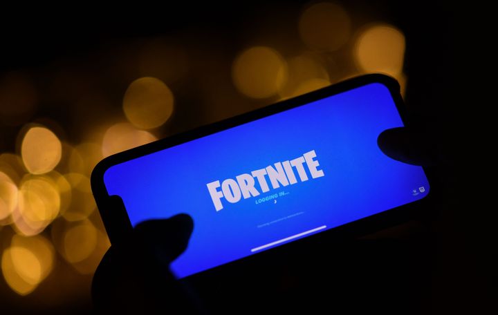 This illustration picture shows a person logging into Epic Games' Fortnite on their smartphone. 