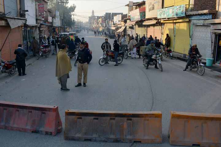 Αξιωματούχοι ασφαλείας φρουρούν σε έναν αποκλεισμένο δρόμο που οδηγεί σε ένα κέντρο αντιτρομοκρατίας όπου αρκετοί κρατούμενοι Πακιστανοί Ταλιμπάν έχουν πάρει ομήρους αστυνομικούς και άλλους μέσα στο συγκρότημα, στο Bannu, μια περιοχή στην επαρχία Khyber Pakhtunkhwa του Πακιστάν, Δευτέρα, 19 Δεκεμβρίου 2022