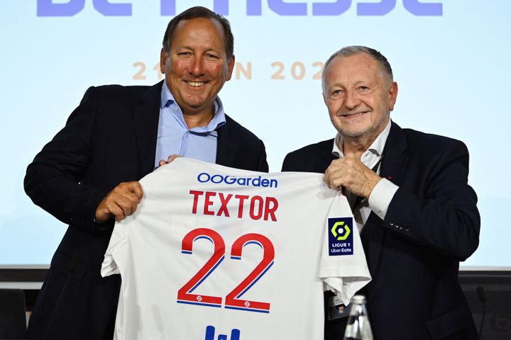 Ο πρόεδρος της ποδοσφαιρικής ομάδας της Λυών, Ζαν-Μισέλ Ολάς (δ) και ο Αμερικανός επιχειρηματίας Τζον Tέξτορ (αρ.) ποζάρουν στο τέλος μιας συνέντευξης Τύπου για να ανακοινώσουν την πώληση μεγάλου μεριδίου του συλλόγου στην Textor's Eagle Football Holdings, στο Decines-Charpieu, κοντά στη Λυών, στις 21 Ιουνίου 2022