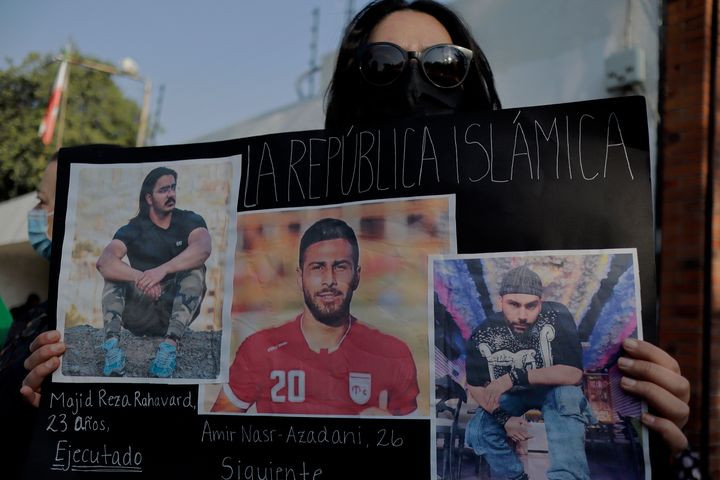 メキシコシティにあるイラン大使館の外で行われた抗議活動。すでに死刑を執行されたモフセン・シェカリさん、マジドレザ・ラフナヴァルドさん、そして死刑宣告されたアミール・ナスル・アザダニ選手の写真を掲げる参加者（2022年12月19日）