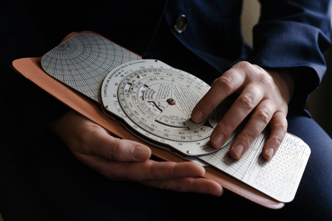 Fredericks holds her father’s E6B flight computer, a flight planning tool that pilots must learn to use manually during training.