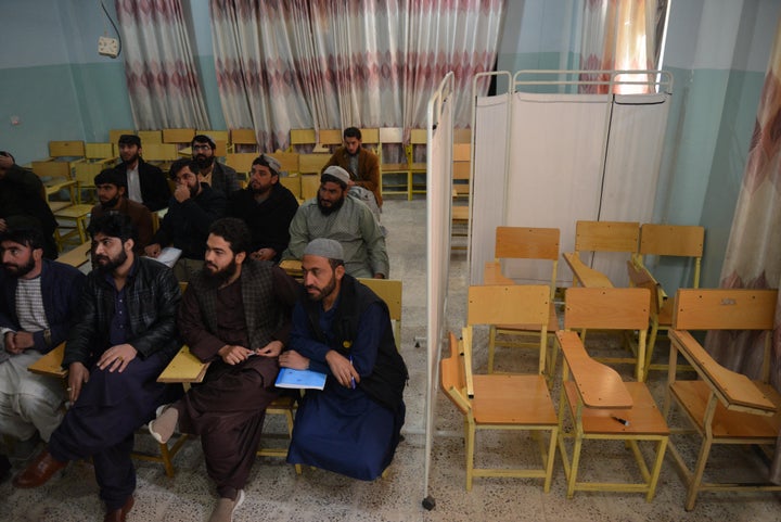 Male university students attend class bifurcated by a curtain separating males and females at a university in Kandahar Province on Dec. 21, 2022. 