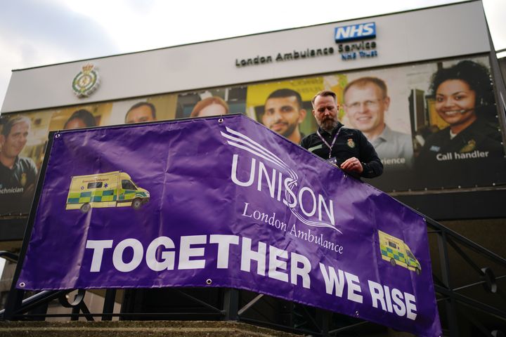A member of staff places a banner on the railings outside Waterloo ambulance station in London, as paramedics, ambulance technicians and call handlers walk out in England and Wales, in a strike co-ordinated by the GMB, Unison and Unite unions over pay and conditions that will affect non-life threatening calls. Picture date: Wednesday December 21, 2022.