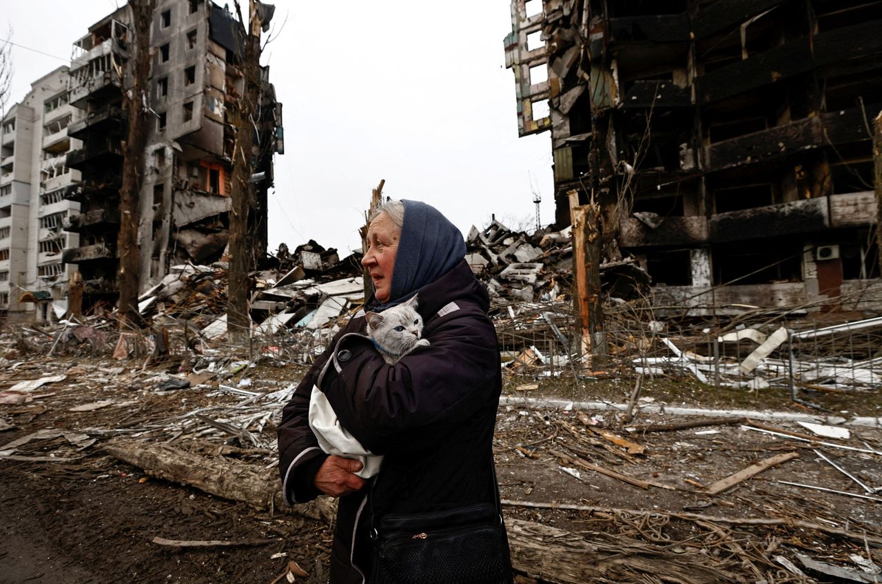 A woman carries her cat as she walks past buildings that were destroyed by Russian shelling, amid Russia's invasion of Ukraine in Borodyanka, in the Kyiv region, Ukraine, on April 5.