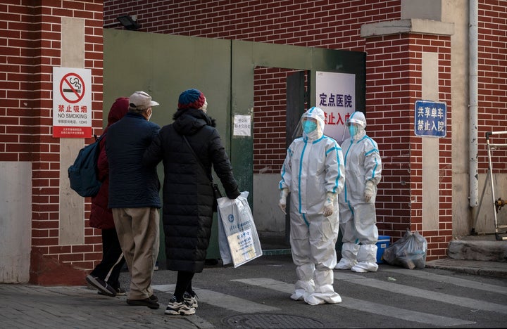 Medical staff wear personal protective equipment as they wait to assist a patient at a fever clinic treating COVID-19 patients on Wednesday in Beijing, China.