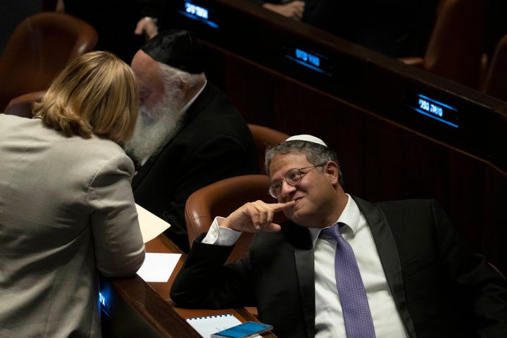 Israeli lawmaker Itamar Ben Gvir speaks to a colleague as lawmakers gather to vote on Yariv Levin as Speaker of the Knesset, Israel's parliament, in Jerusalem, Tuesday, Dec. 13, 2022. (AP Photo/ Maya Alleruzzo)