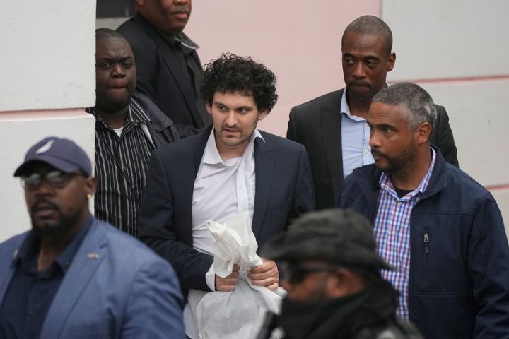 FTX founder Sam Bankman-Fried, center, is escorted from the Magistrate Court in Nassau, Bahamas, on Dec. 21, 2022, after agreeing to be extradited to the U.S.