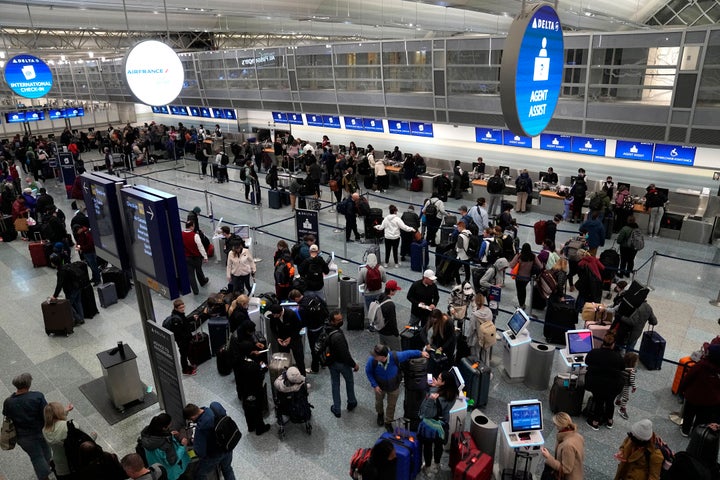 Travelers check in for their flights at kiosks and wait in line to check luggage in Terminal 1 at Minneapolis St. Paul Airport, Wednesday, Dec. 21, 2022, in Minneapolis. (AP Photo/Abbie Parr)