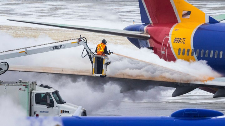 Crews deice a Southwest Airlines plane before takeoff on Wednesday, Dec. 21, 2022 in Omaha, Neb. An incoming winter storm threatens the Christmas travel rush. (Chris Machian/Omaha World-Herald via AP)