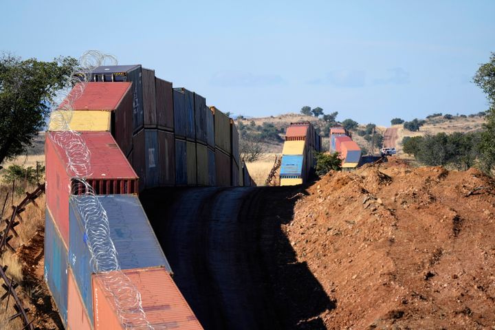 A long row of double-stacked shipping containers provide a new wall between the United States and Mexico in the remote section area of San Rafael Valley, Ariz., on Dec. 8, 2022. Arizona Gov. Doug Ducey will take down a makeshift wall made of shipping containers at the Mexico border, settling a lawsuit and political tussle with the U.S. government over trespassing on federal lands. 