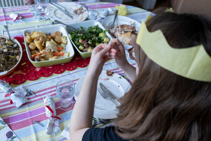 A young woman tries to solve a cracker novelty puzzle after a family lunch on Christmas Day.