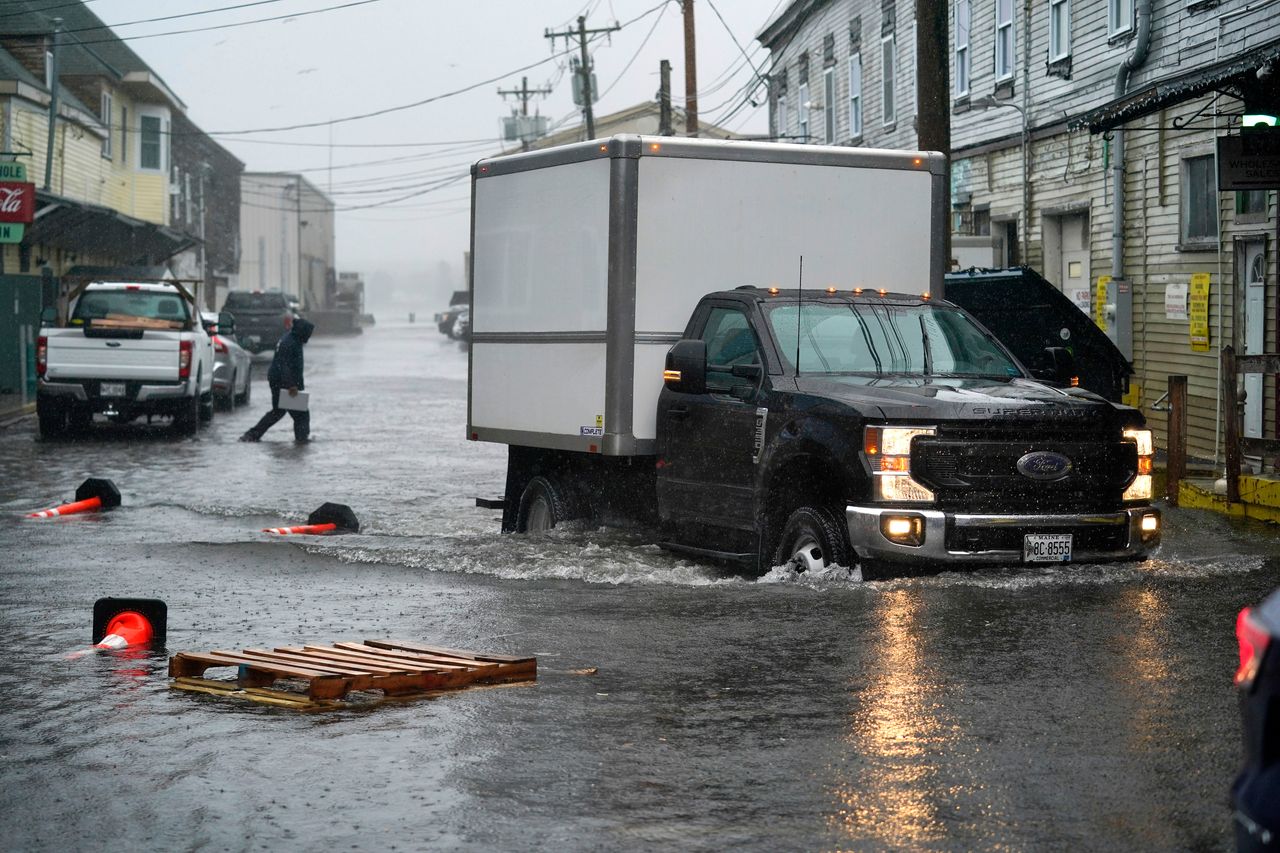 A delivery truck drives through floodwaters on the Portland, Maine, waterfront on Friday. 