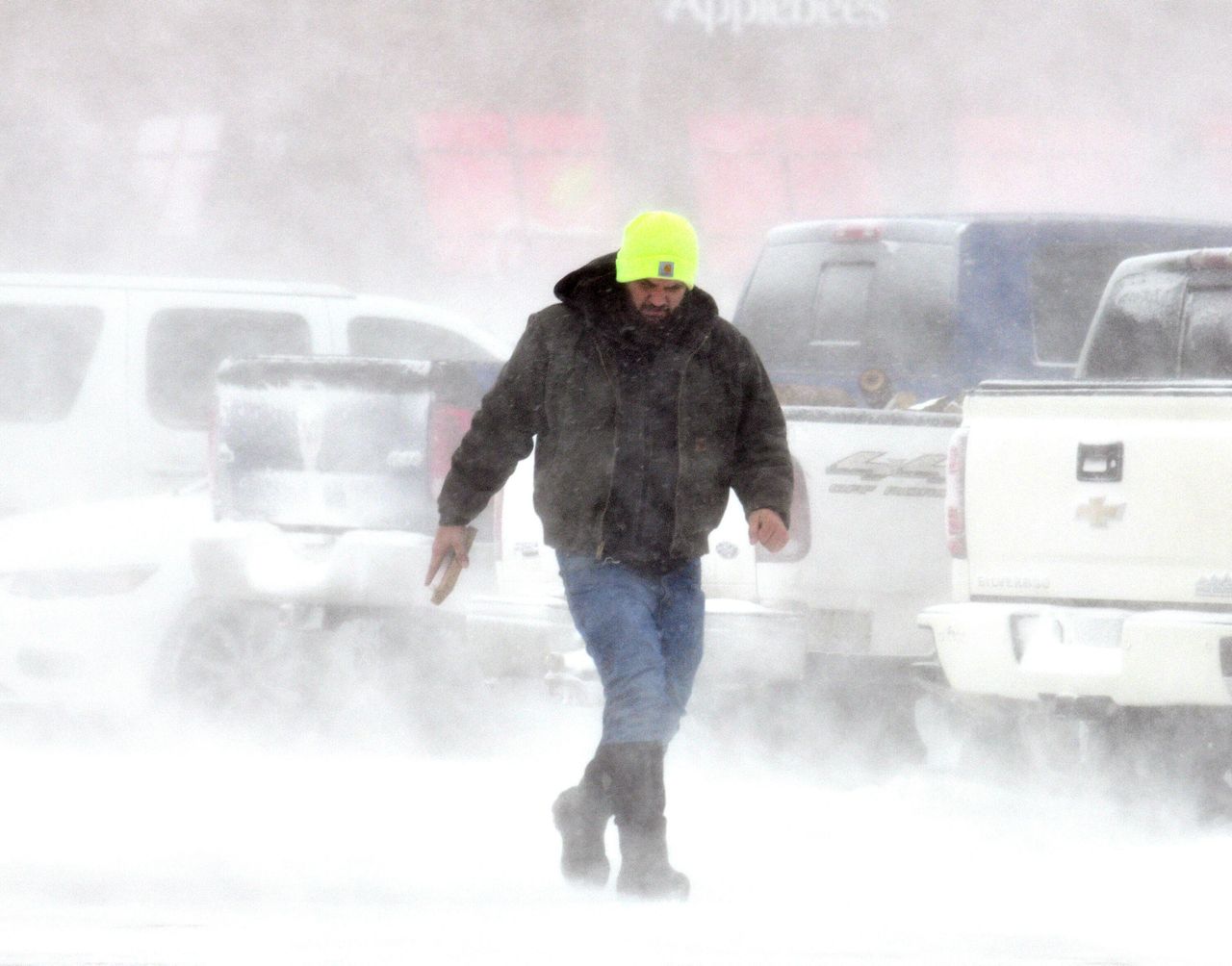 A shopper is surrounded by blowing snow in Ashtabula, Ohio, on Friday.