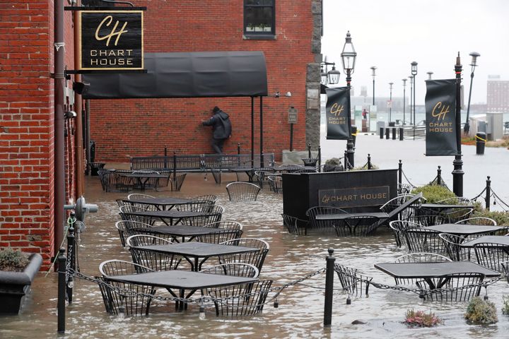 Water floods a restaurant terrace during high tide on Long Wharf in Boston on Friday.