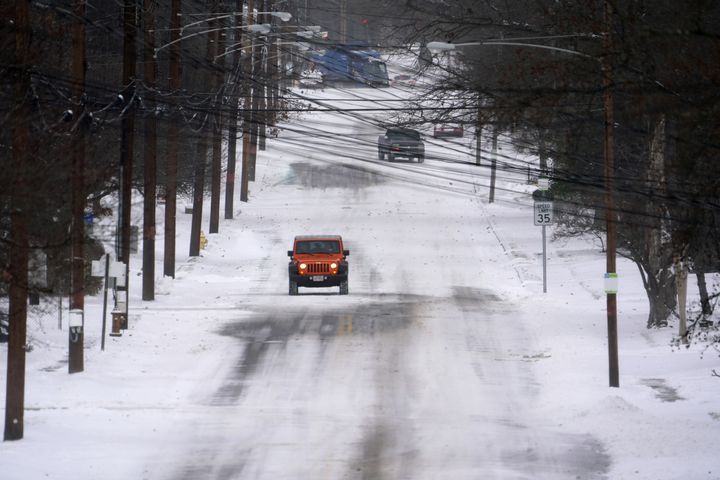 Vehicles travel along Birney Lane, Friday, Dec. 23, 2022, in Anderson Township, Ohio. Winter weather is blanketing the U.S. as a massive storm sent temperatures crashing and created whiteout conditions. (Kareem Elgazzar /The Cincinnati Enquirer via AP)