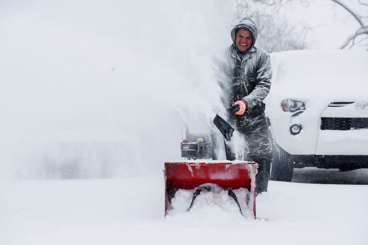 Francisco Erazo uses his snow blower to clear snow on Friday, Dec. 23, 2022 in Grand Rapids, Mich. A blizzard warning is in effect for Kent County and the surrounding region. Winter weather is blanketing the U.S. as a massive storm sent temperatures crashing and created whiteout conditions. (Neil Blake/The Grand Rapids Press via AP)