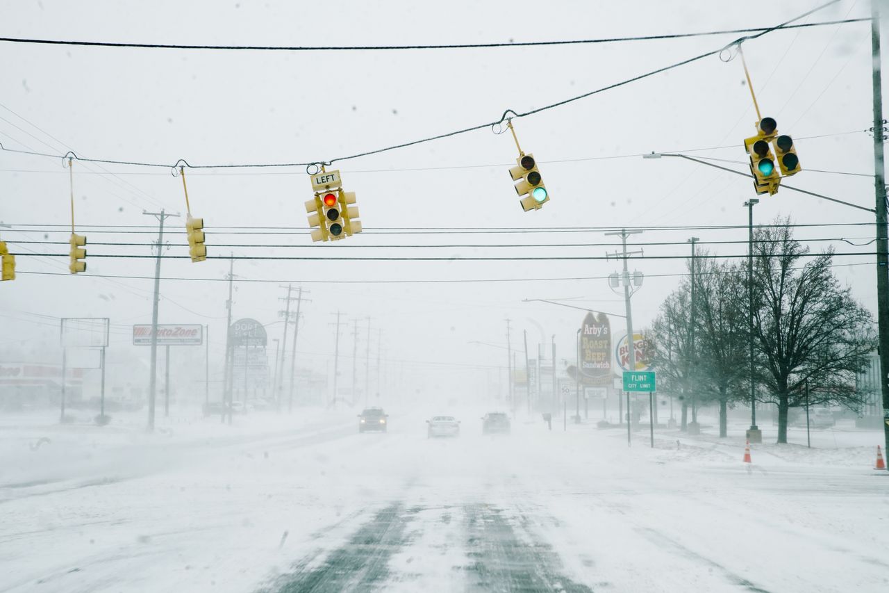 FLINT, MICHIGAN-DECEMBER 23- Street lights and snow blow in severe wind gusts during a massive winter storm affecting most of the USA., in Flint, MI on December 23, 2022. (Photo by Katie McTiernan/Anadolu Agency via Getty Images)