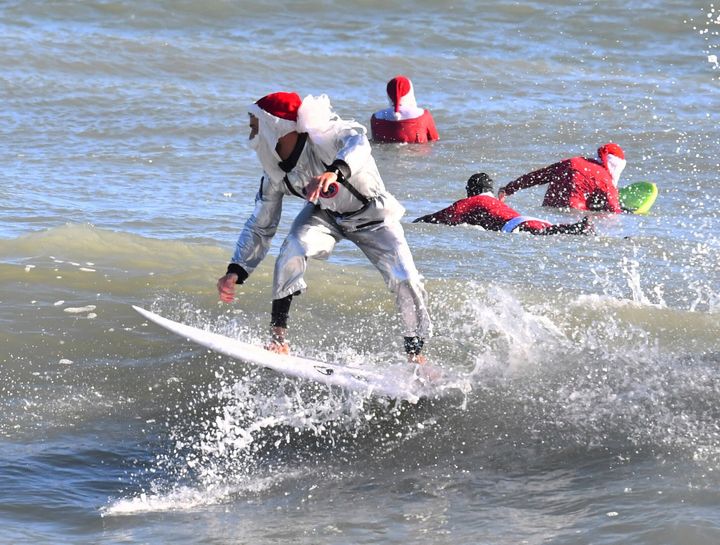 Cold temperatures thinned out the surfers but thousands showed up for the annual holiday event that benefits the Florida Surf Museum and Grind for Life, a local charity benefiting people with cancer.