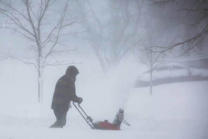 A person clears snow as a winter storm rolls through Western New York Saturday, Dec. 24, 2022, in Amherst N.Y. A battering winter storm has knocked out power to hundreds of thousands of homes homes and businesses across the United States on Saturday. It left millions more to worry about the prospect of further outages and crippled police and fire departments.(AP Photo/Jeffrey T. Barnes)