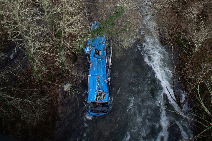 A bus lies in a river after an accident near Pontevedra in northwestern Spain Dec. 26, 2022.