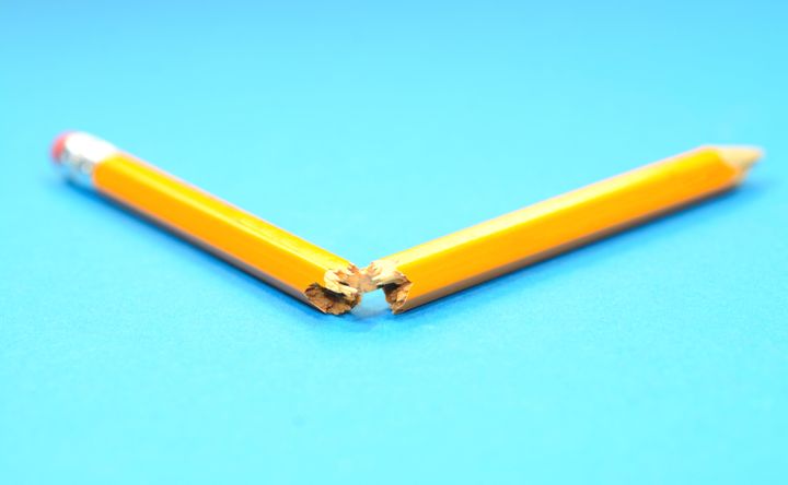 Yellow broken pencil on a blue background.
