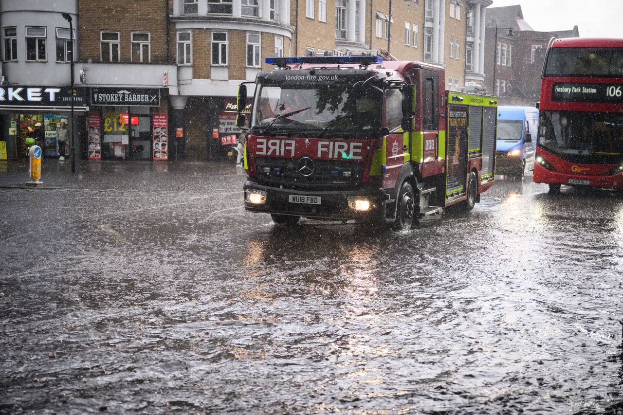 A fire engine negotiates a flooded section of road, as torrential rain and thunderstorms hit the country on August 17, 2022 in London.