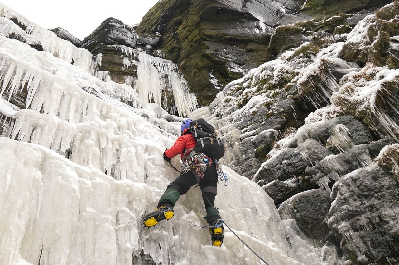A man ice climbing on the frozen Kinder Downfall, High Peak in Derbyshire on December 18, 2022.