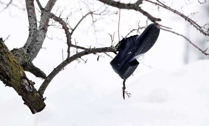 Ένα παπούτσι κρέμεται σε δέντρο στην πανεπιστημιούπολη του Buffalo South στο Μπάφαλο, Νέα Υόρκη, την Τρίτη, 27 Δεκεμβρίου 2022. Η χιονοθύελλα έπληξε τέσσερις κομητείες της Δυτικής Νέας Υόρκης. (Joseph Cooke/The Buffalo News via AP)