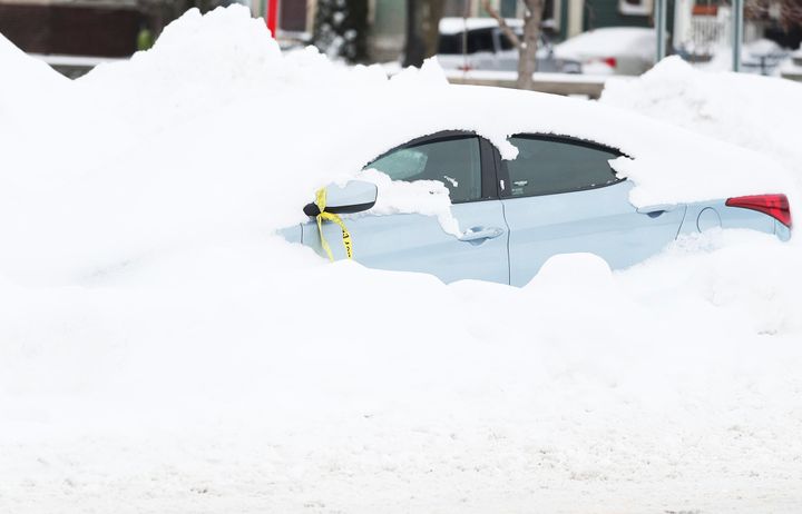 Ένα εγκαταλελειμμένο αυτοκίνητο είναι καλυμμένο με χιόνι στην Main Street στο Μπάφαλο της Νέας Υόρκης, την Τρίτη 27 Δεκεμβρίου 2022, μερικά 24ωρα αφότου μια χιονοθύελλα έπληξε τέσσερις κομητείες της Δυτικής Νέας Υόρκης. (Joseph Cooke/The Buffalo News via AP)