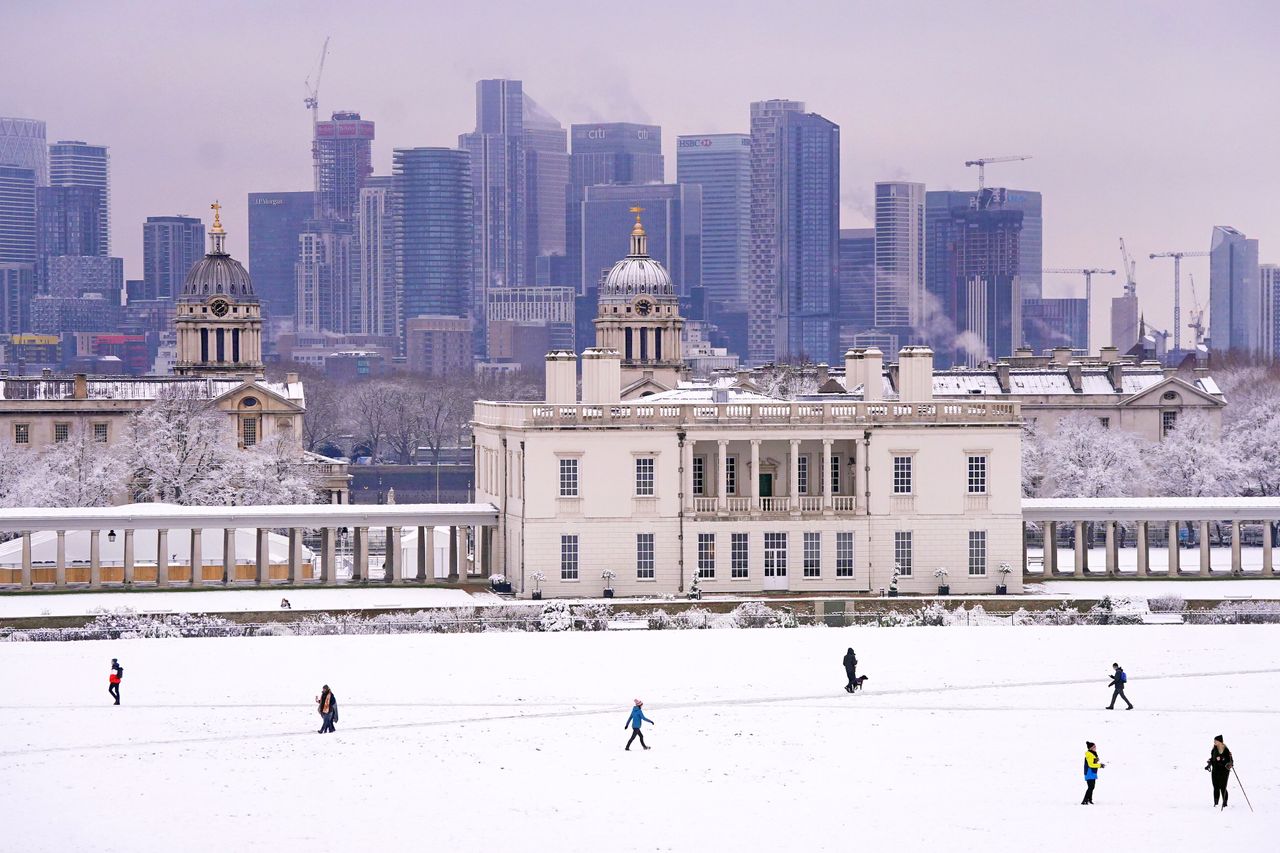 People walk through the snow in Greenwich Park, south-east London on December 12, 2022.