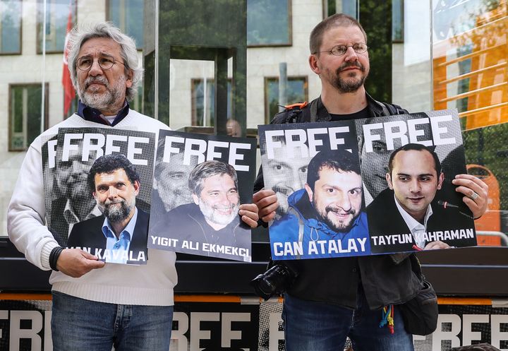 O Τούρκος αντιφρονών δημοσιογράφος Can Dündar (αριστερά) και ο Γερμανός Πέτερ Στόιντνερ (δεξιά) κρατούν πανό με τις εικόνες των φυλακισμένων πολιτικών ακτιβιστών μαζί με άλλους διαδηλωτές μπροστά από την Τουρκική Πρεσβεία για να απαιτήσουν την ελευθερία του Oσμάν Καβαλά και επτά άλλων κατηγορουμένων που καταδικάστηκαν σε ποινές φυλάκισης στην Τουρκία στις 4 Μαΐου 2022 στο Βερολίνο της Γερμανίας.