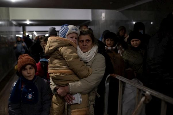 3月10日、ウクライナ西部リビウからポーランドに向かう電車を家族と待つ母親