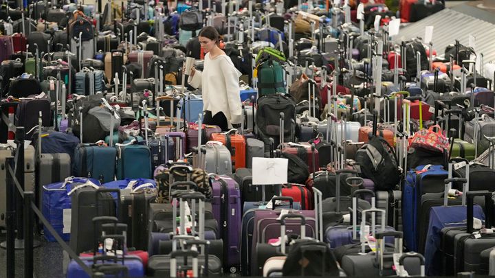 A woman walks through unclaimed bags at Southwest Airlines baggage claim at Salt Lake City International Airport on Thursday. Southwest Airlines is still trying to extract itself from sustained scheduling chaos and cancelled another 2,350 flights after a winter storm overwhelmed its operations days ago.
