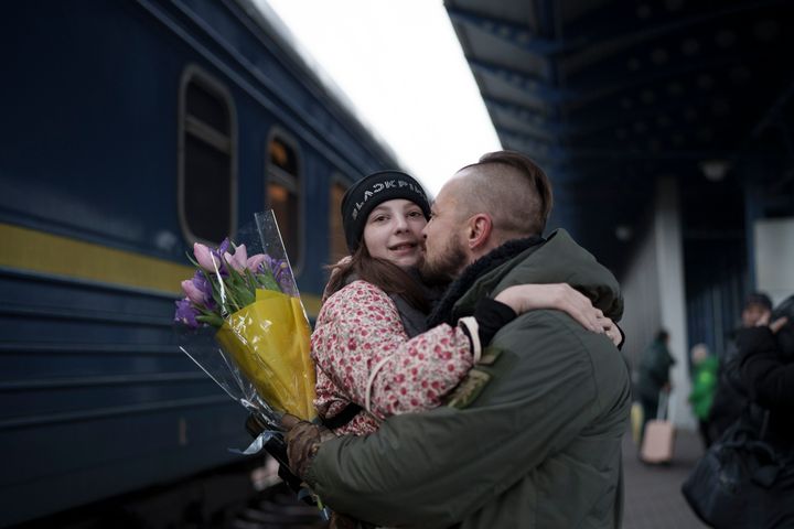 Ukrainian soldier Vasyl Khomko, 42, hugs his daughter Yana as she arrives at the railway station in Kyiv, Ukraine, on Saturday December 31, 2022.  Khomko's wife and daughter lived in Slovakia due to the war, but returned to Kyiv to spend New Year's Eve together.  (AP Photo/Roman Hrytsyna)