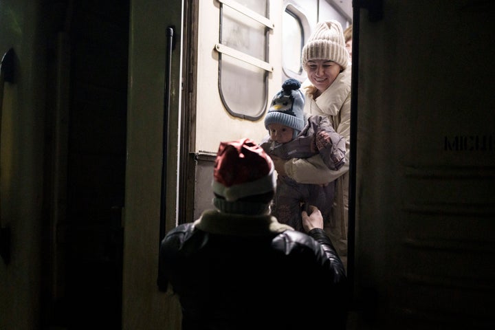 Dmytro receives Tatyana and their 5-months-old son Volodymyr at the train station as they arrive to spend New Year's together in Kyiv, Ukraine, Saturday, Dec. 31, 2022. (AP Photo/Roman Hrytsyna)