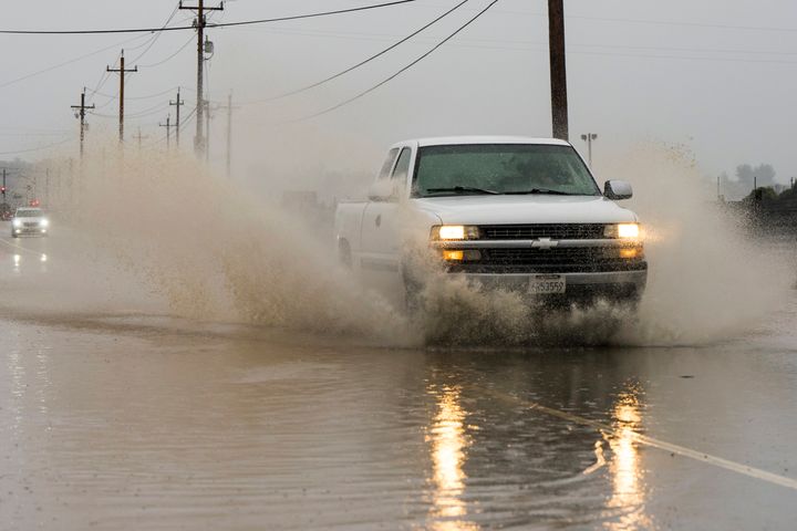 A truck drives through a flooded section of Harrison Road in Salinas, Calif., Saturday, Dec. 31, 2022. (AP Photo/Nic Coury)